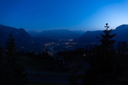 A mountain range, a city and a tree during the colorful sunset - beautiful nature