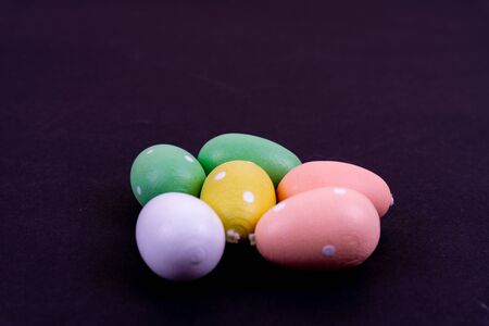 Close up of a few colorful easter eggs laying on black backgroundの写真素材