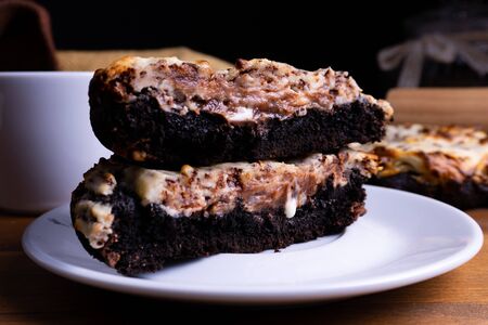 Delicious cookie cakes with chocolate and cheesecake with a cup of coffee on a wooden board with copy spaceの写真素材