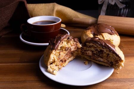 Delicious cookie cakes with chocolate with a cup of coffee on a wooden board with copy spaceの写真素材
