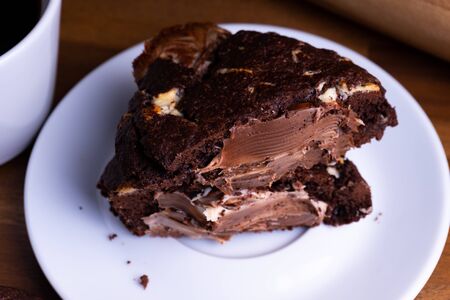 Delicious cookie cakes with chocolate with a cup of coffee on a wooden board with copy spaceの写真素材
