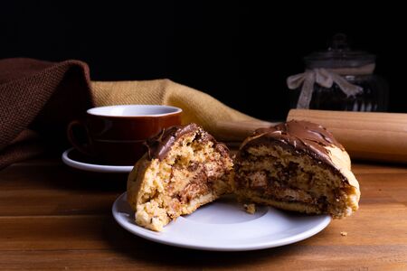 Delicious cookie cakes with chocolate with a cup of coffee on a wooden board with copy spaceの写真素材