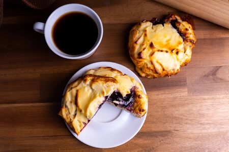Delicious cheesecake cookie cakes with blueberries and a cup of coffee on a wooden board with copy spaceの写真素材