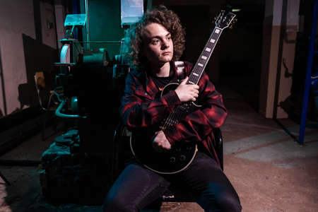 portrait of a musician. Handsome young man with musical instruments.