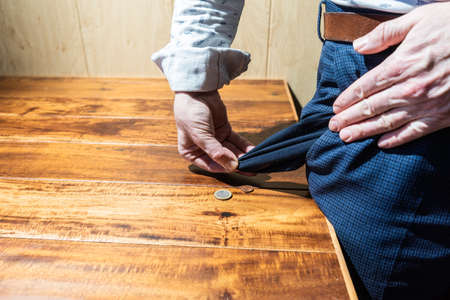 Man or businessman showing his empty pocket. coins on the table