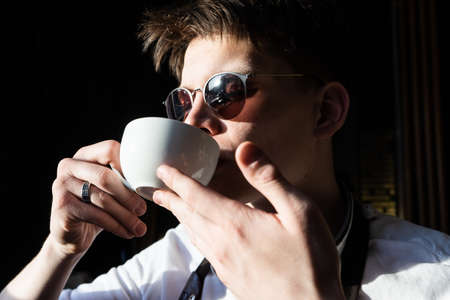 young man drinking coffee or tea. barista tasting coffeeの写真素材