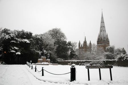 Cardiff cathedral beyond fence and field with treeの写真素材