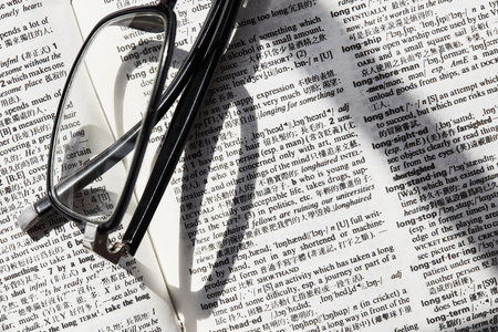 Reading glasses on a bookの写真素材