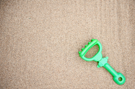 Plastic rake toy on beach sandの写真素材