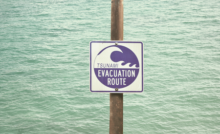 Tsunami Evacuation Route Signage with water in the backgroundの写真素材