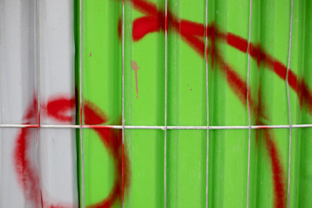 Red spray paint on a green and white metalの写真素材