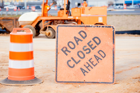Ornage barrel and road closed sign at construction site heavy equipment の写真素材