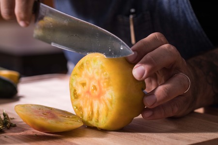 Heirloom tomato being slicedの写真素材