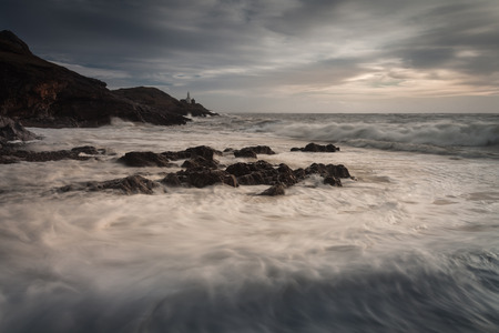 Sea foam covered Bracelet Bay on the Gower peninsula, Swanseaの写真素材