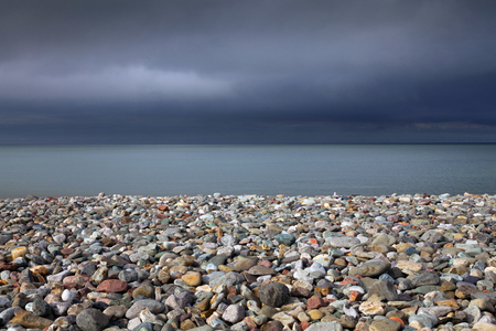 Pebble covered beach and a stormy sky at Llandudno, North Wales.の写真素材