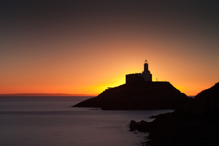 Daybreak at Mumbles lighthouse, an iconic structure in Swansea Bay, Swansea, South Walesの写真素材