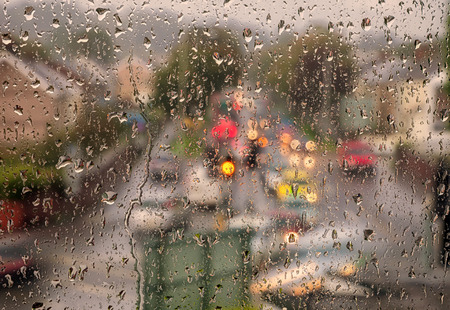 Swansea in the rain, one of the wettest cities in Britain, as seen through a window onto a traffic light junction.の写真素材