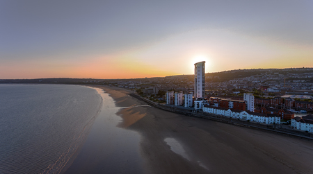 Editorial SWANSEA, UK - July 25, 2018: Dusk and sunset behind the Meridian Tower and housing development on Swansea Bay, South Wales, UKのeditorial素材