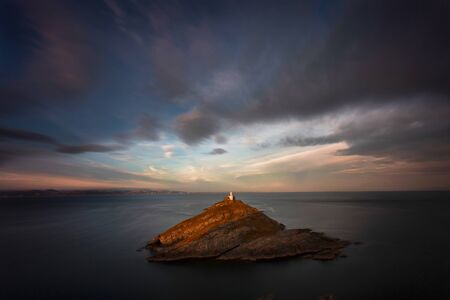 The iconic landmark that is Mumbles Lighthouse on the Gower peninsula in Swansea, South Wales, UK.