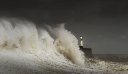 Porthcawl lighthouse and pier in the jaws of a storm on the coast of South Wales, UK.の写真素材