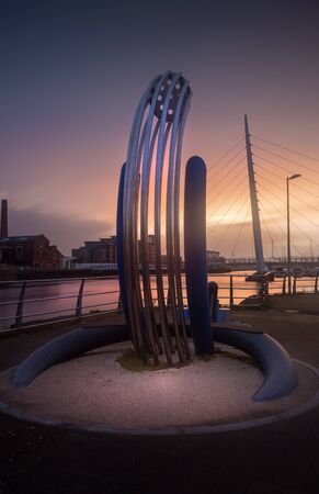 Editorial SWANSEA, UK - DECEMBER 08, 2019: The riverside sculpture and Swansea Sail Bridge on the...