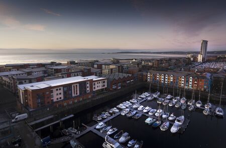 Editorial Swansea, UK - January 21, 2020: Dawn at Swansea Marina showing the Meridian Tower, yachts, housing, Swansea Bay and Mumbles headland.のeditorial素材