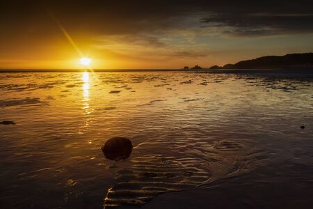 A Winter sunrise over a low tide at Swansea Bay and Mumbles pier, UKの写真素材