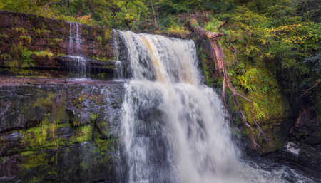 The power of water at the ledged waterfall on the Mellte river after days of rain near Pontneddfechan in South Wales, UK.の写真素材
