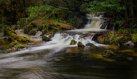 A waterfall flowing into the river Elan just outside the town centre of Rhayader in Mid Wales UKの写真素材