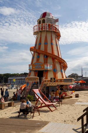 Editorial Weymouth, UK - September 11th, 2021:A Summer scene on Weymouth Beach in England featuring a Helter Skelter slide.のeditorial素材