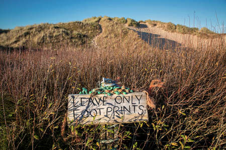 A sign on Rhossili beach on the Gower Peninsula requesting people to leave only footprints, the area is prone to holiday makers leaving rubbish on the beaches and debri washed ashore.の写真素材
