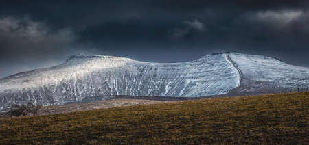 Snow covered Brecon Beacons mountains in South Wales, UK showing the twin summits of Penyfan and Corn Duの写真素材