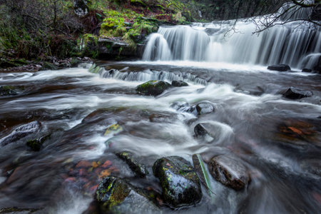 A long exposure over the rock strewn waterfalls at Blaen y Glyn a few miles northwest of Usk in South Wales UKの写真素材