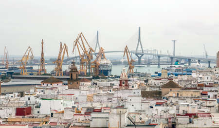 Editorial Cadiz, Spain - March 22, 2022: The cranes, ships and La Pepa suspension bridge in Cadiz in Spain.のeditorial素材