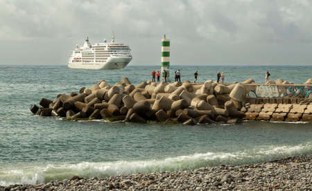 Editorial Madeira, Portugal - March 28, 2022: A cruise ship arriving near the green and white lighthouse in Funchal, Madeira, Portugal.のeditorial素材