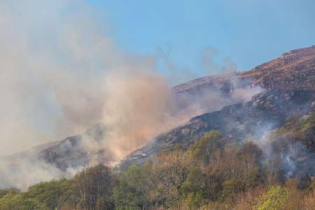 Editorial Scotland, UK - April 22, 2022: Firemen at Morar in Scotland attempt to control a grass fire on a hillside.のeditorial素材