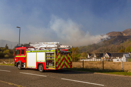 Editorial Scotland, UK - April 22, 2022: Firemen at Morar in Scotland attempt to control a grass fire on a hillside.のeditorial素材