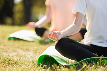 Detail of women doing yoga outdoors at sunrise. Morning meditationの写真素材