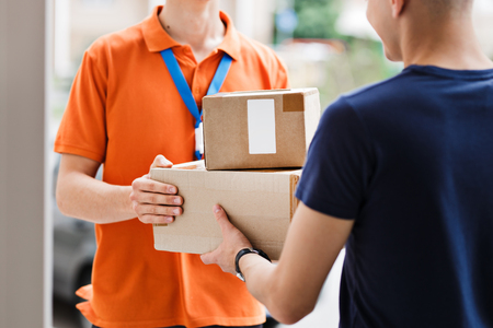 A person wearing an orange T-shirt and a name tag is deliveringの写真素材