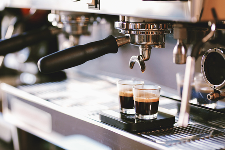 The coffee is poured into the cup in a cozy coffee shop.の写真素材