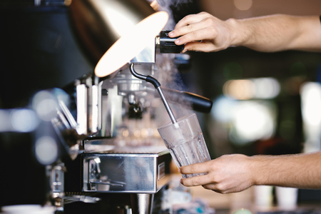 A modern expensive coffee machine is shown in work in  modern cozy coffee shop.の写真素材