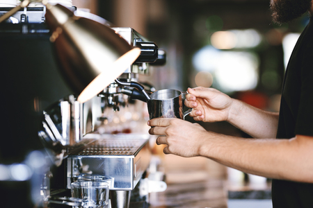A modern expensive coffee machine is shown in work in  modern cozy coffee shop.の写真素材