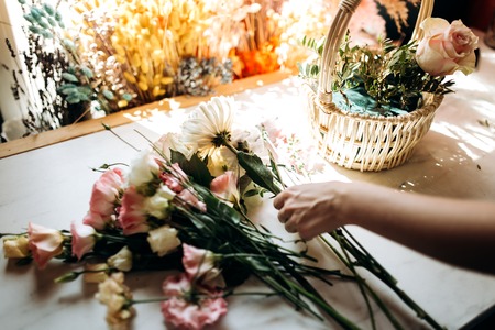 Florist collections a bouquet in the basket from fresh chamomile and eustoma in the flower shopの写真素材