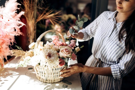 Florist collections a bouquet in the basket from fresh flowers of pastel colors in the flower shopの写真素材