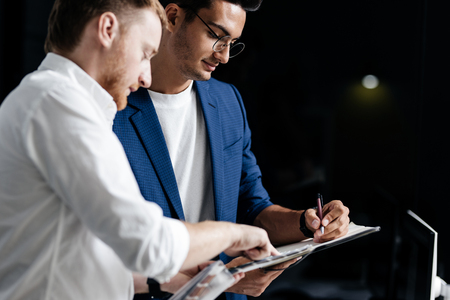 Two professional architects discuss sheet with drawing in the officeの写真素材