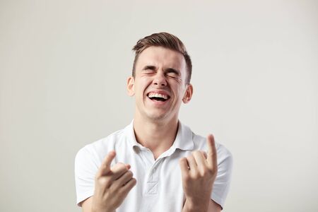 Guy dressed in a white t-shirt and jeans nickers on a white background in the studioの写真素材