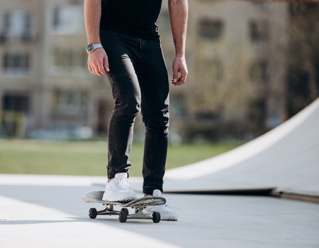 The man rides skateboard on a platform outside next to the house at the sunny warm dayの写真素材