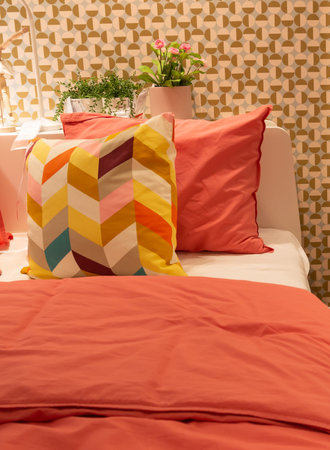 Orange color cotton bedroom textiles. Modern bedroom interior.の写真素材