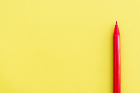 Red marker isolated on yellow background, after some edits.の写真素材