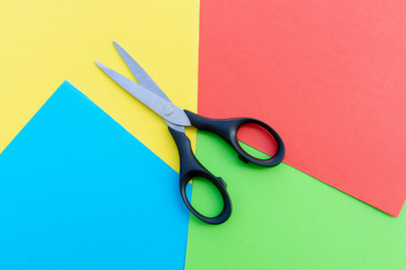 Scissors placed on colored papers, after some edits.の写真素材